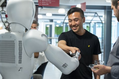 man schudt een robot de hand
